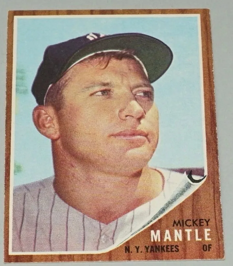 A raw, ungraded 1962 Topps Mickey Mantle card with visible corner and edge wear